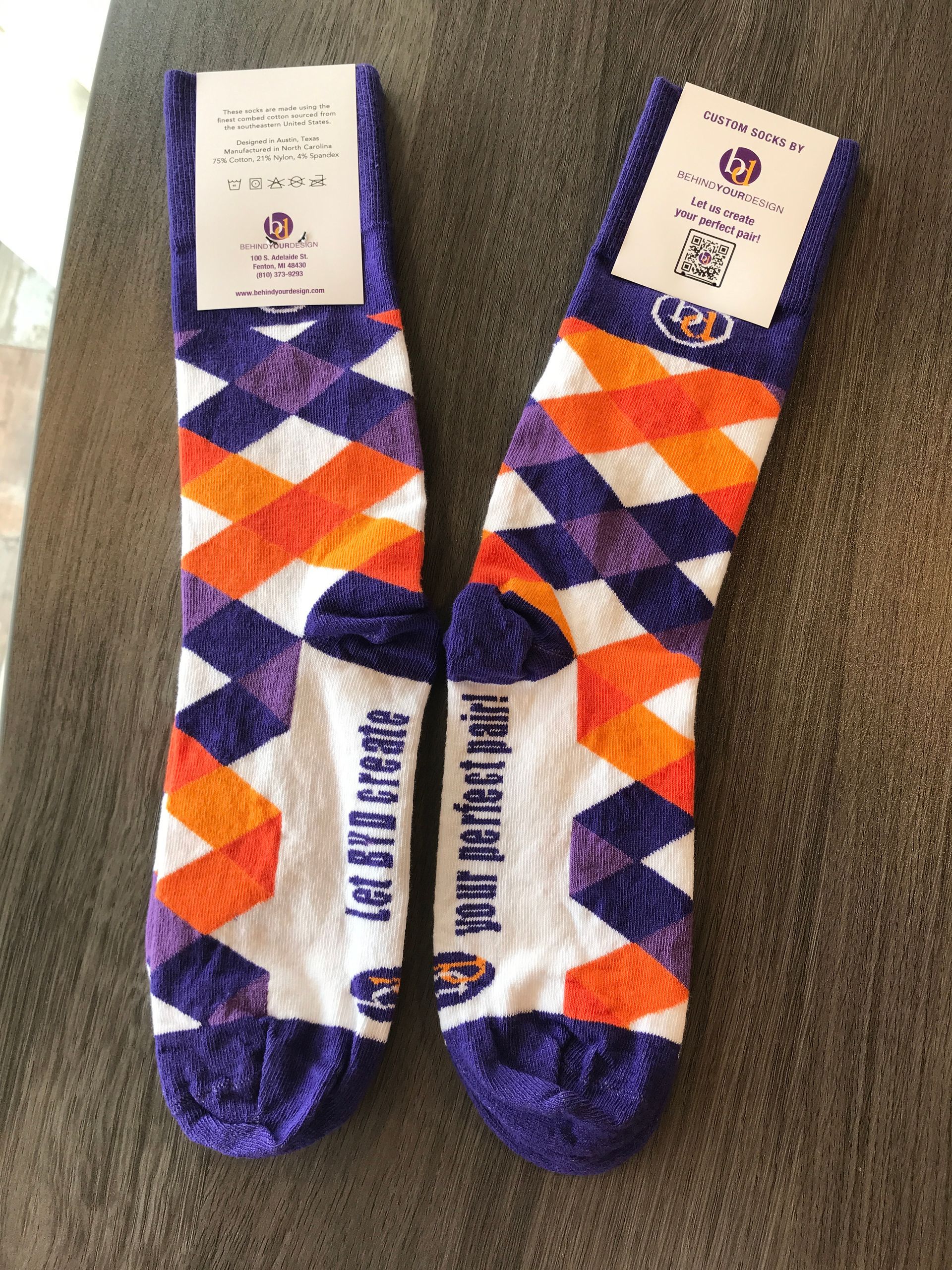 A pair of purple and orange socks are sitting on a table.