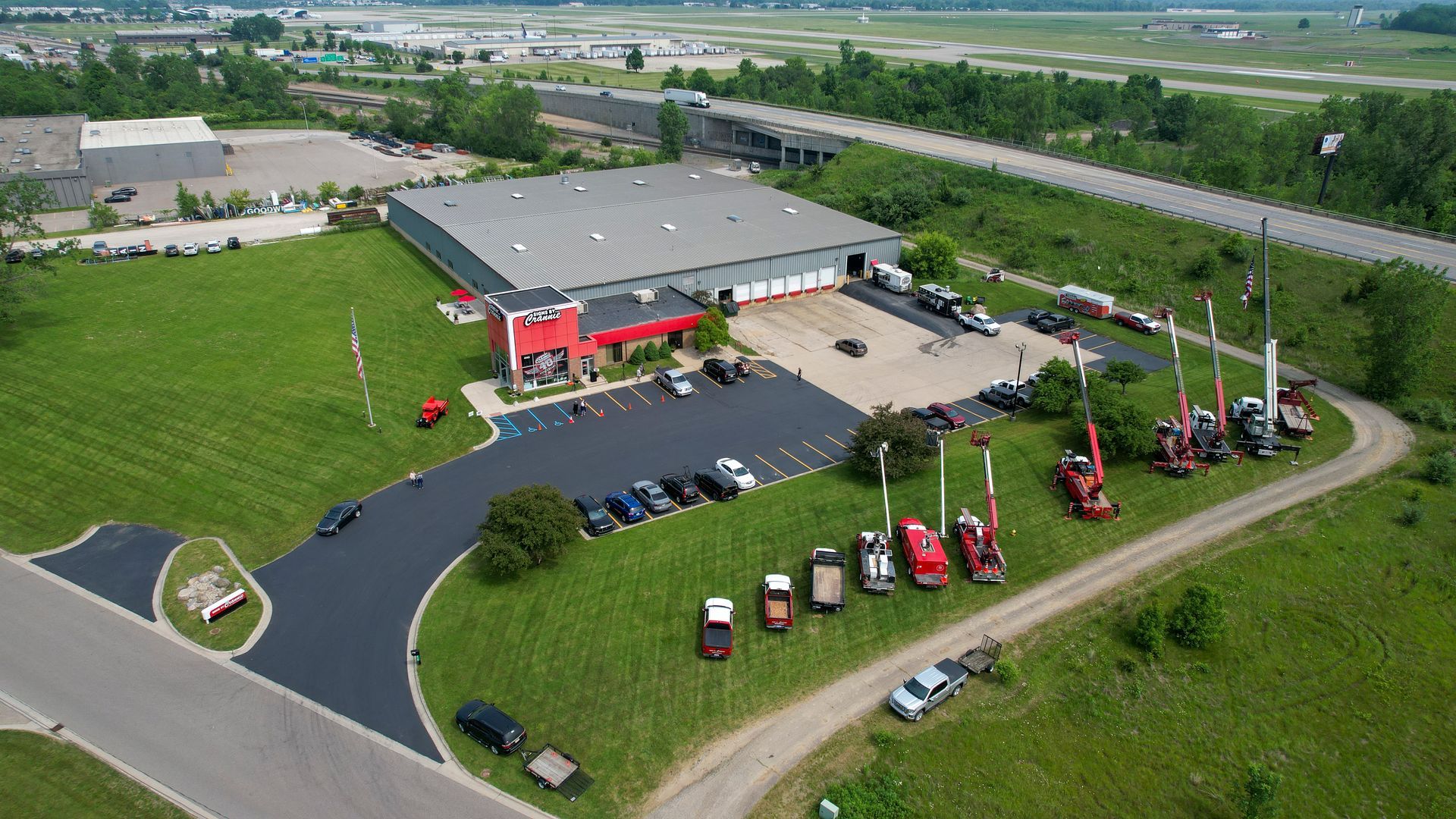 An aerial view of a large building with a lot of cars parked in front of it.