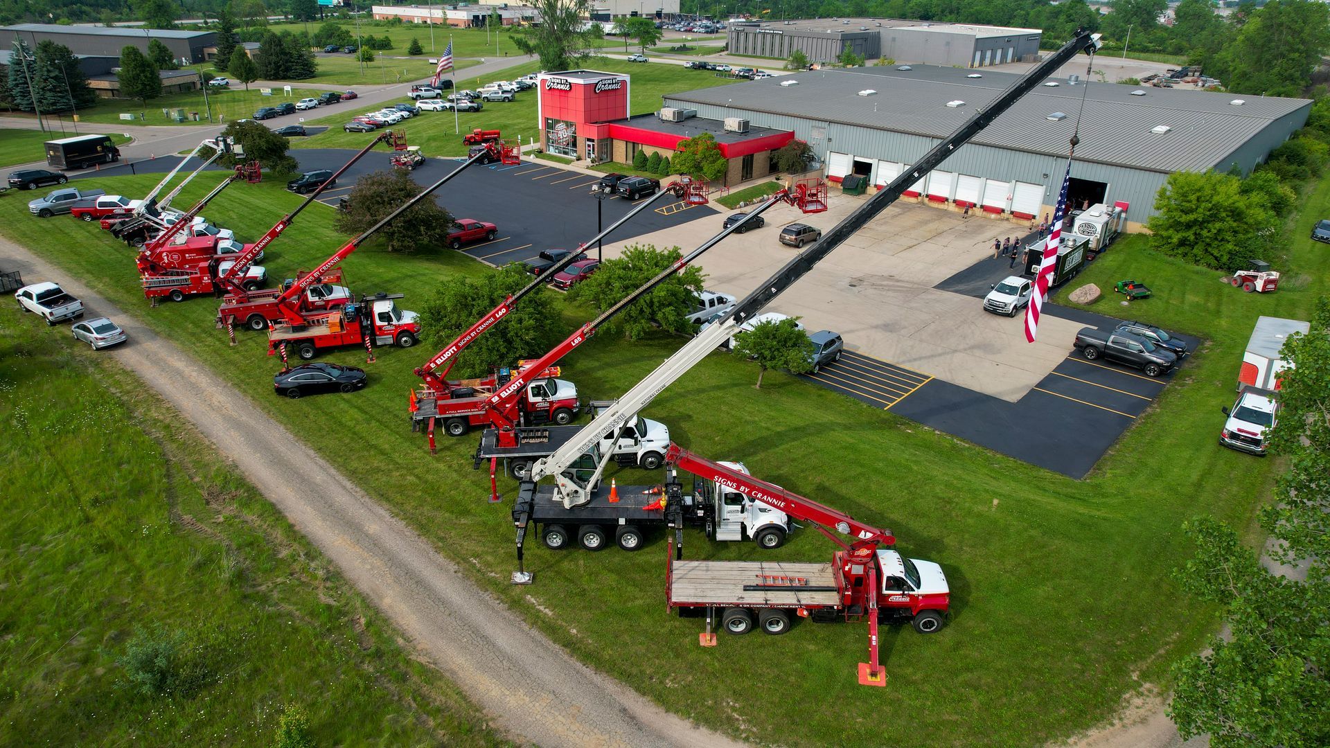 An aerial view of a large building with a lot of trucks parked in front of it.