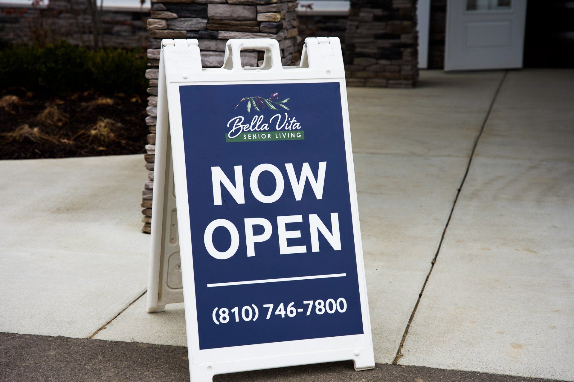 A blue and white sign that says now open
