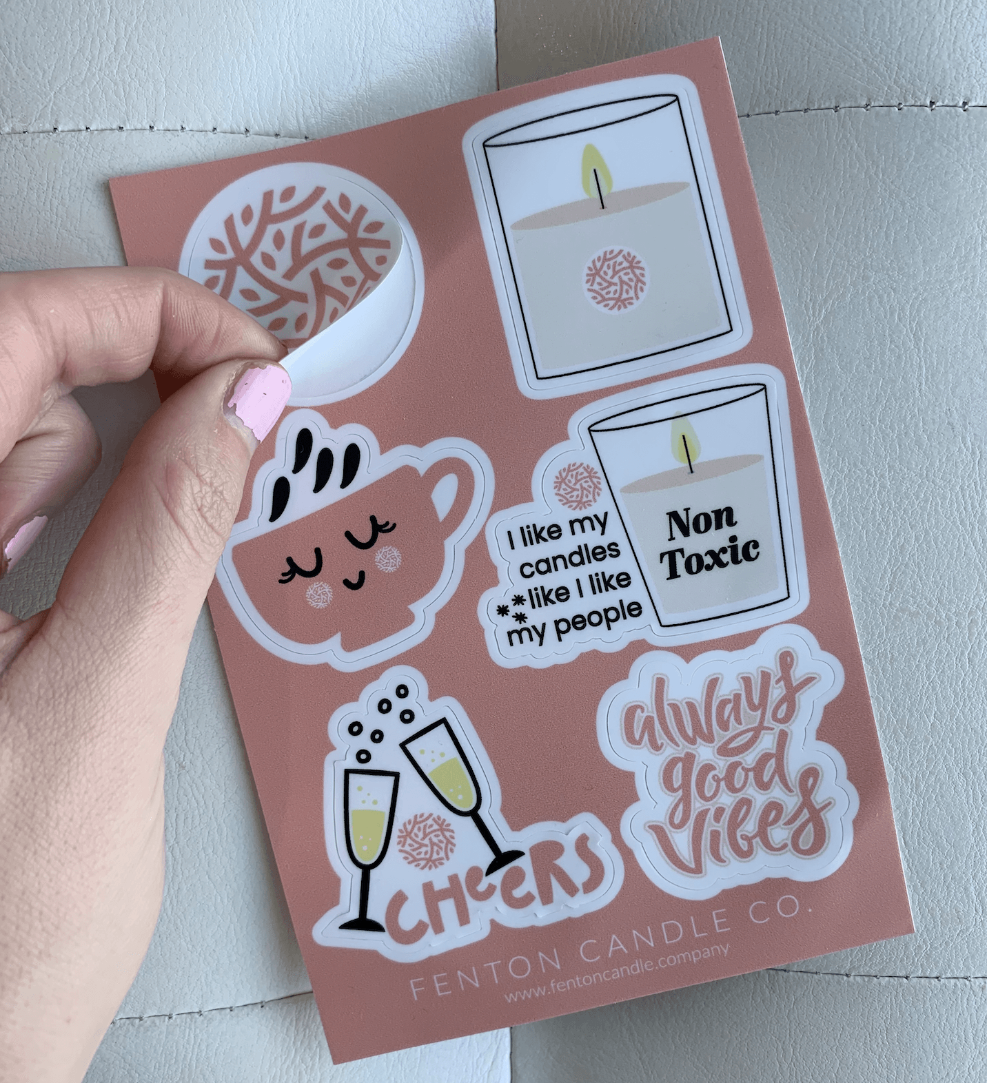A person is holding a sheet of stickers that say cheers and always good vibes
