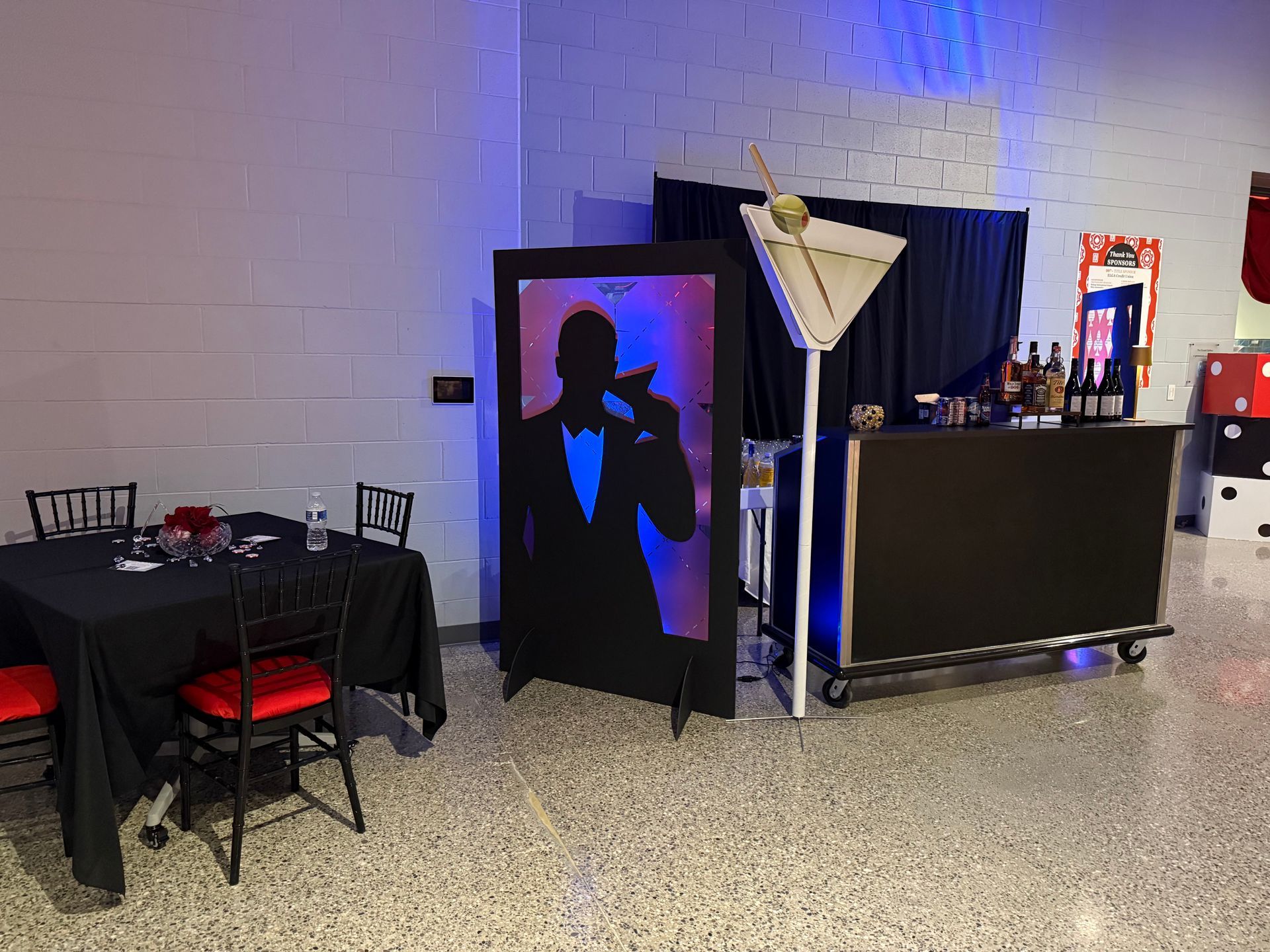 A room with tables and chairs and a martini bar.