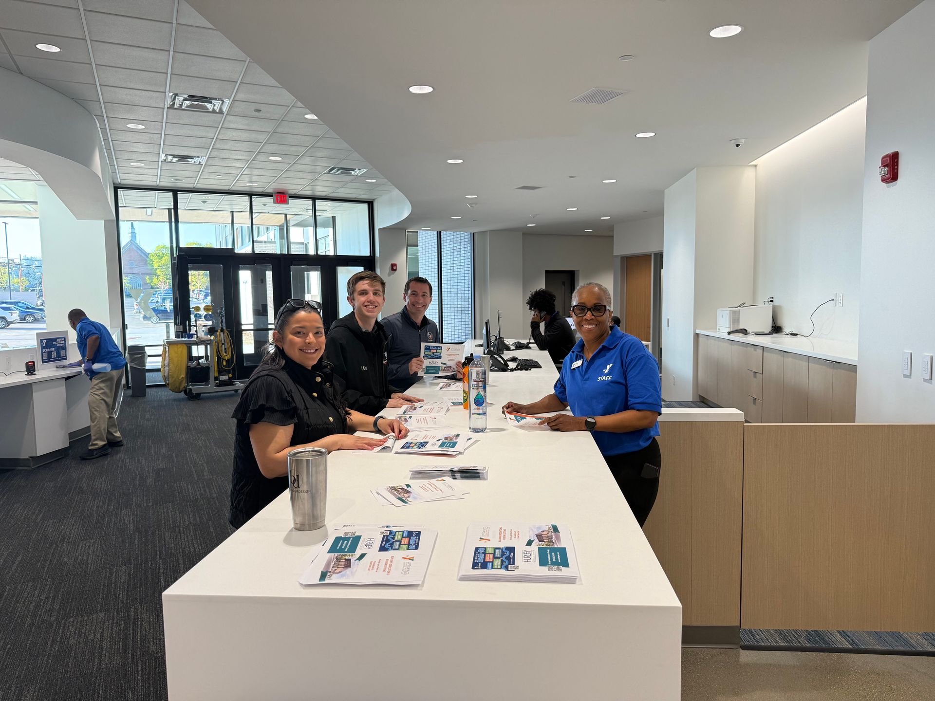 A group of people are sitting at a long table in a store.