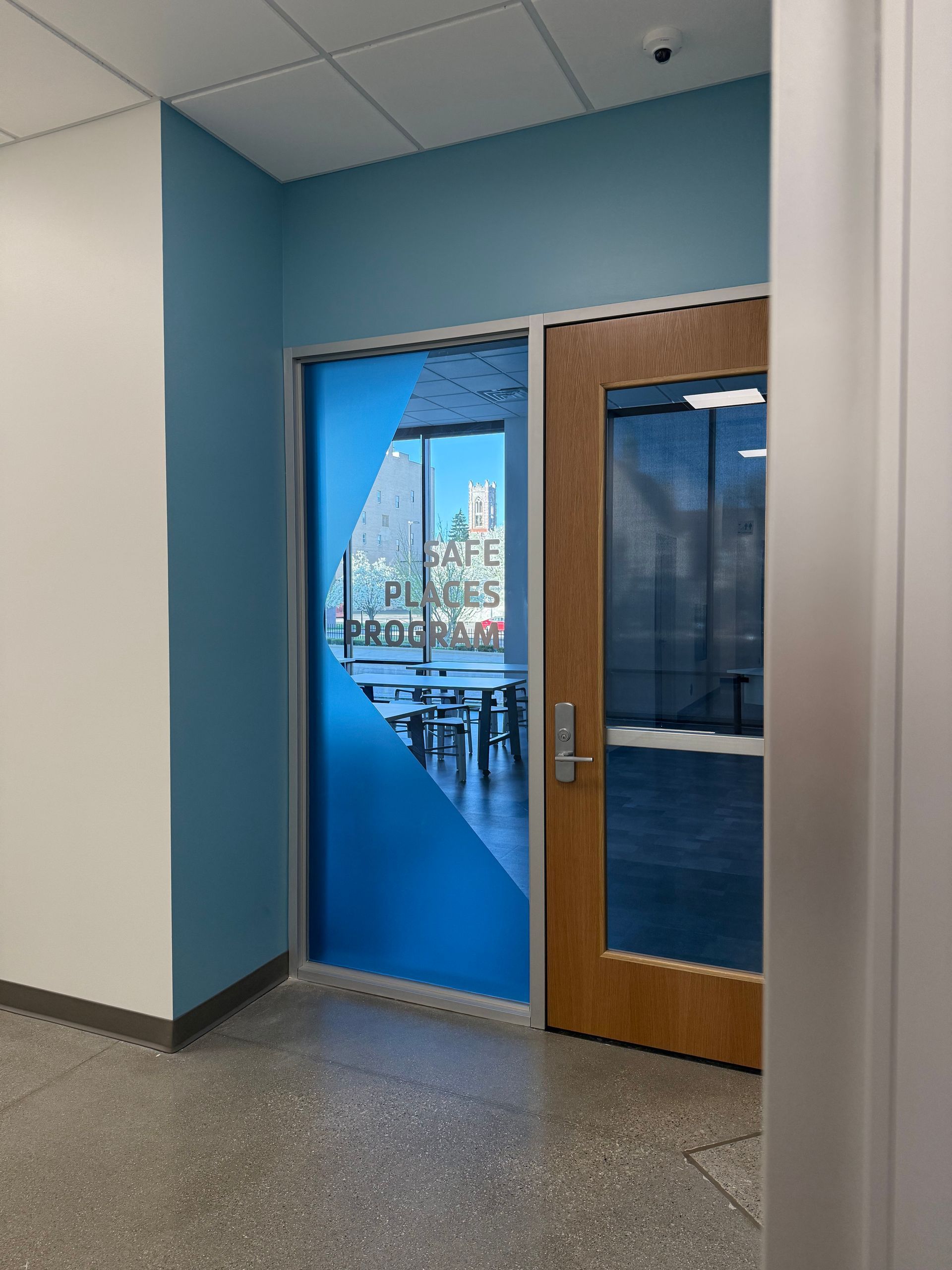 A hallway with blue walls and a wooden door