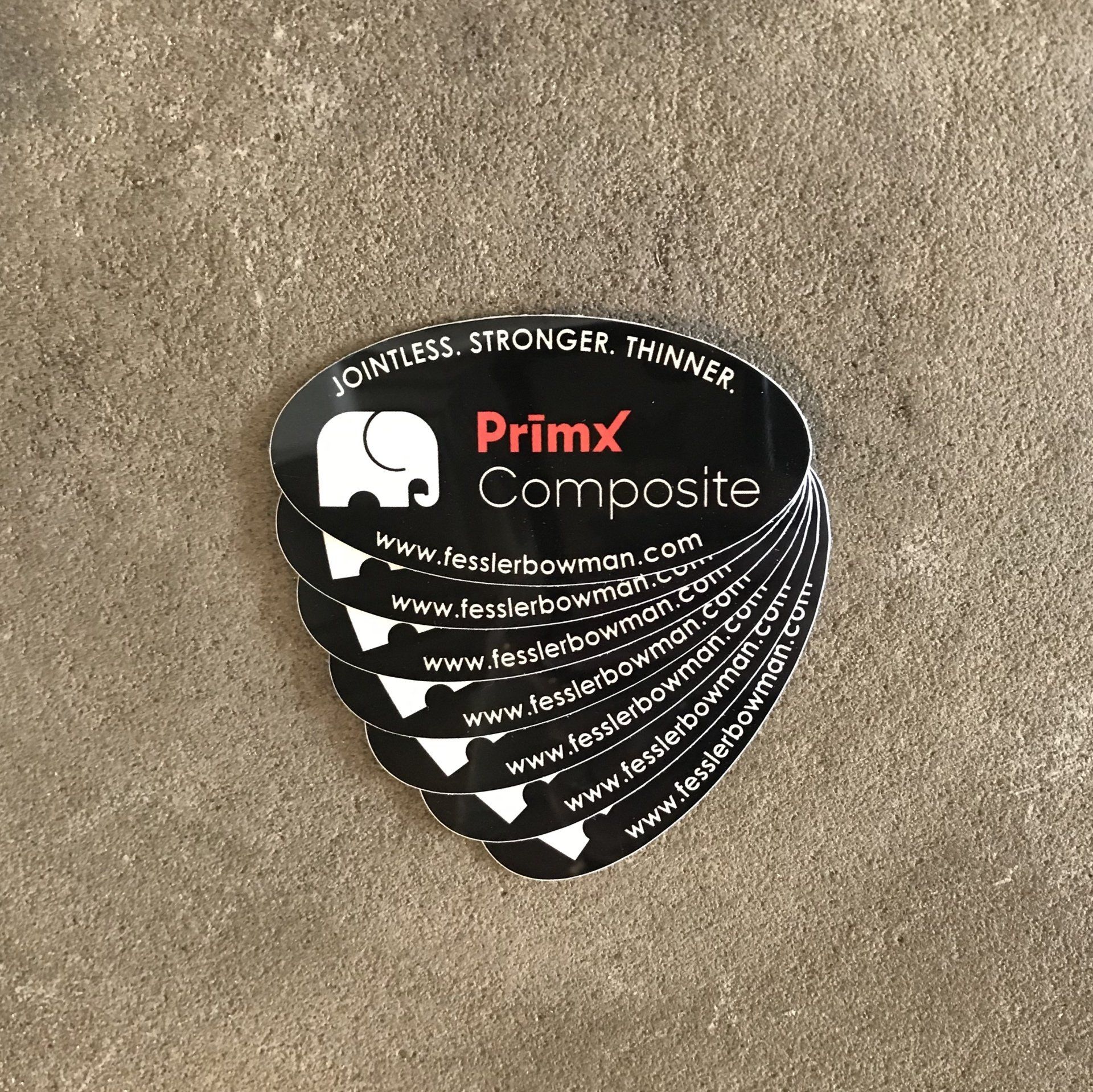 A stack of primx composite stickers on a table