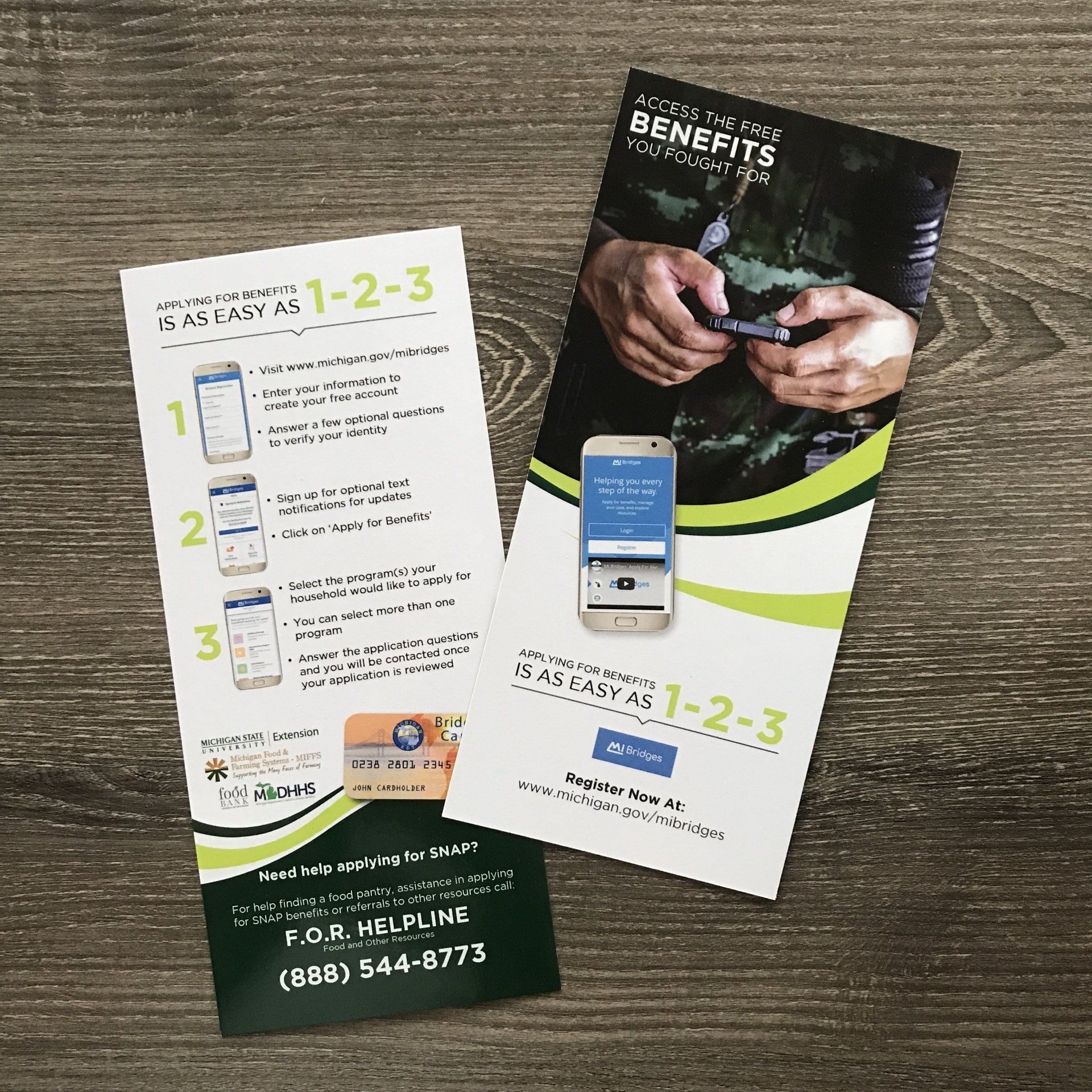 Two pamphlets are sitting on a wooden table.