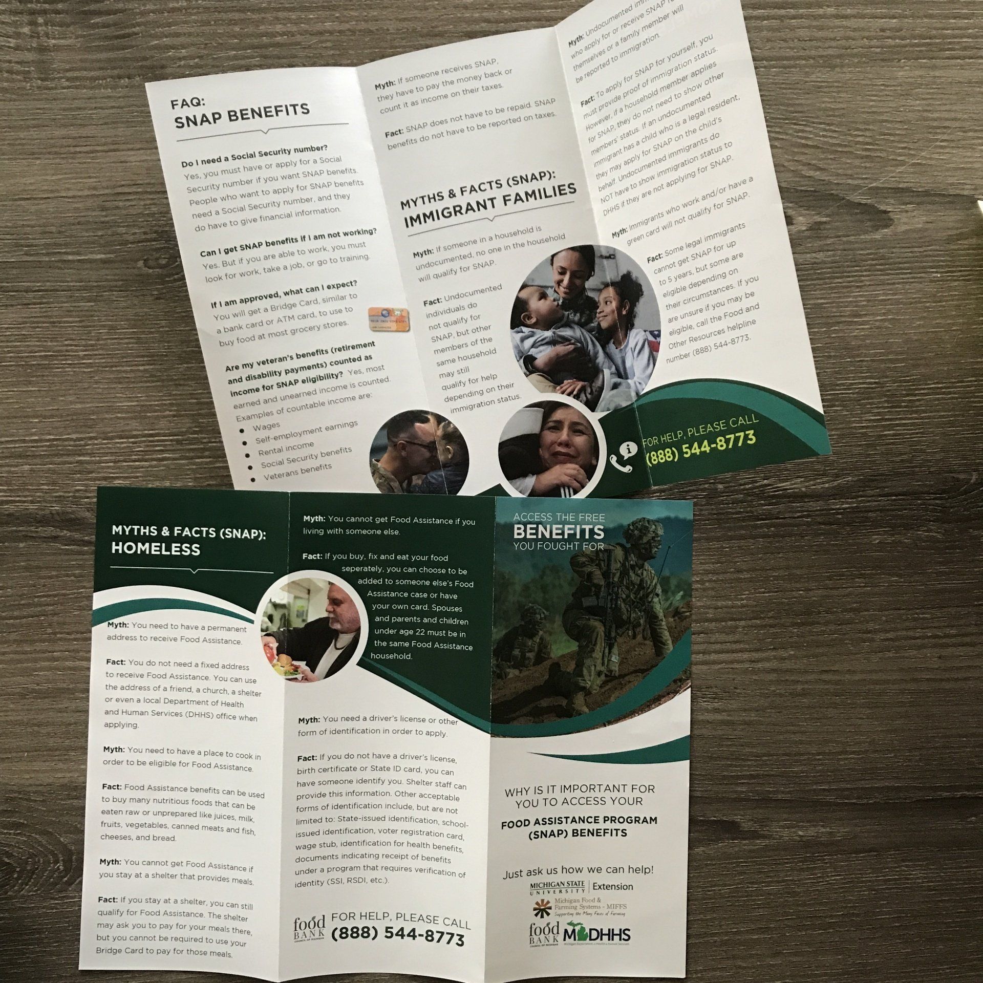 A green and white brochure is sitting on a wooden table.