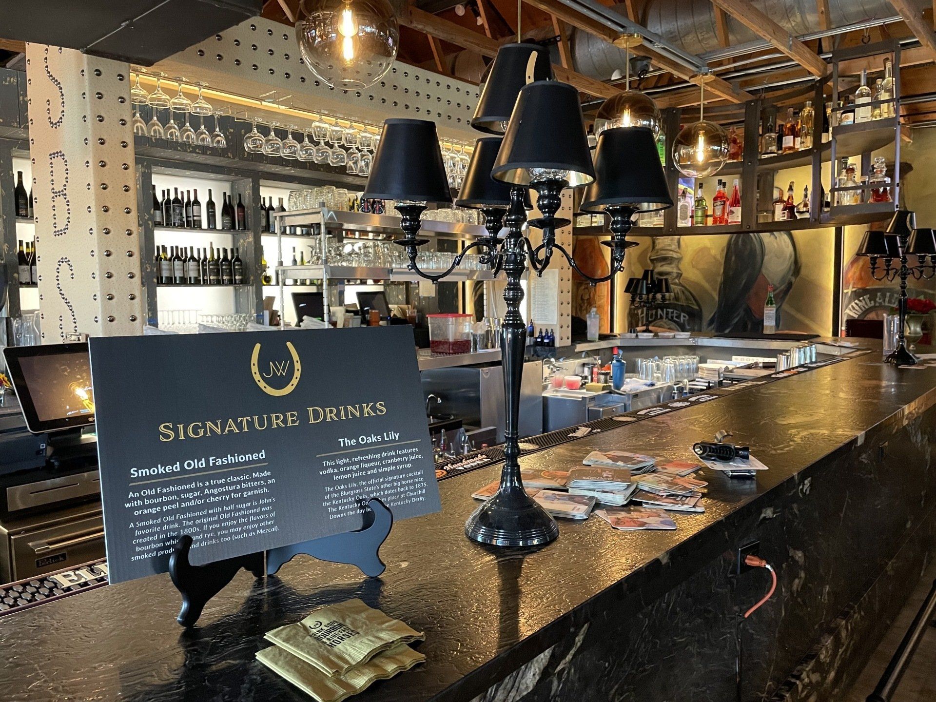 A bar with a sign that says signature drinks on it