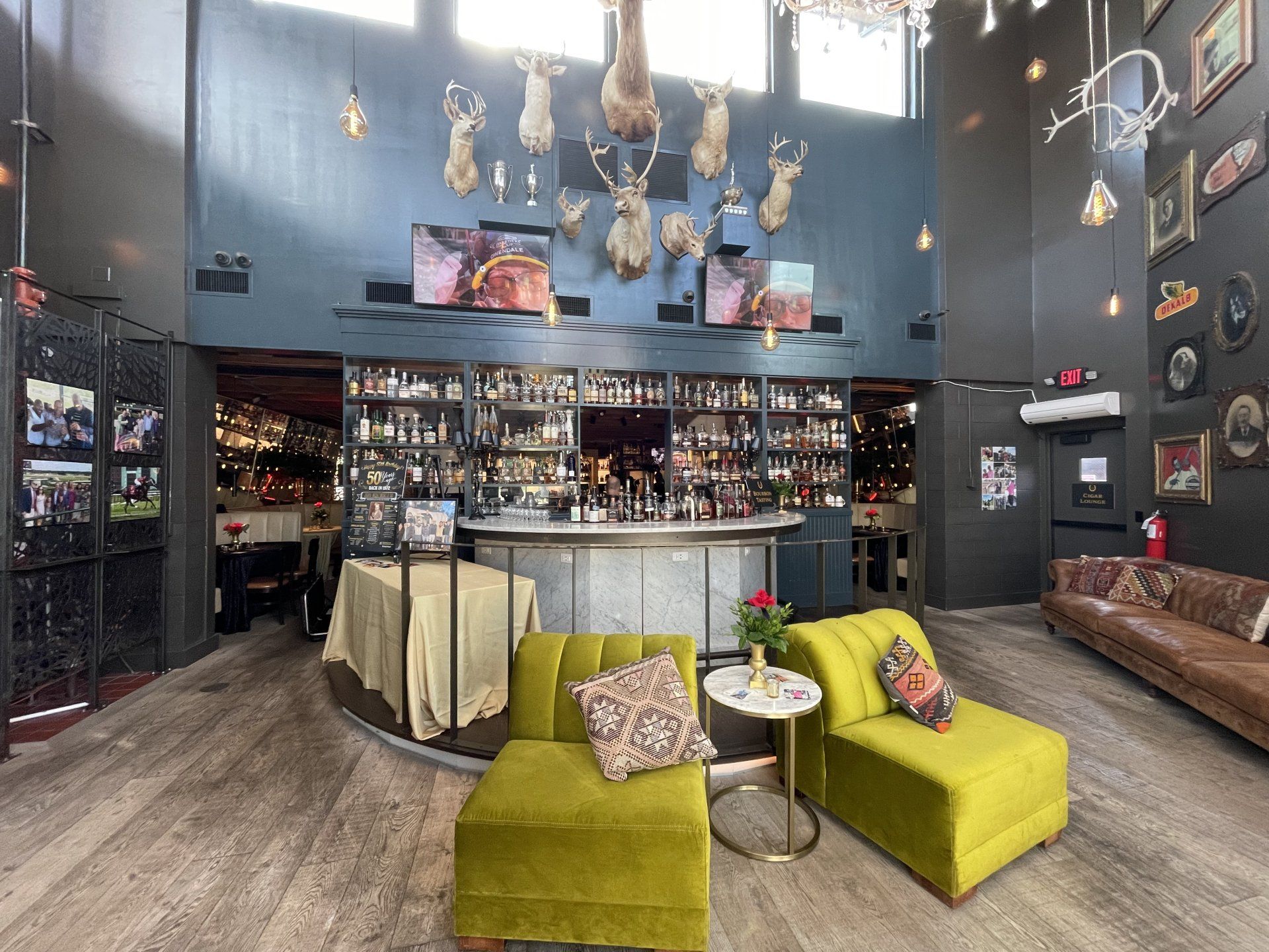 A large room with a bar , chairs , and a couch.