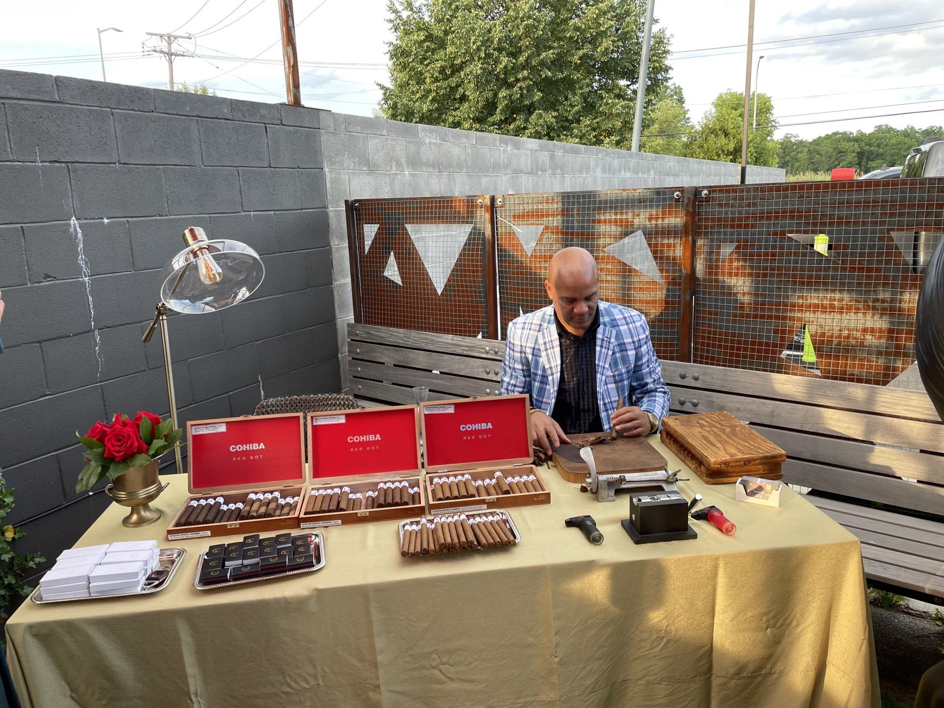 A man is sitting at a table making cigars.