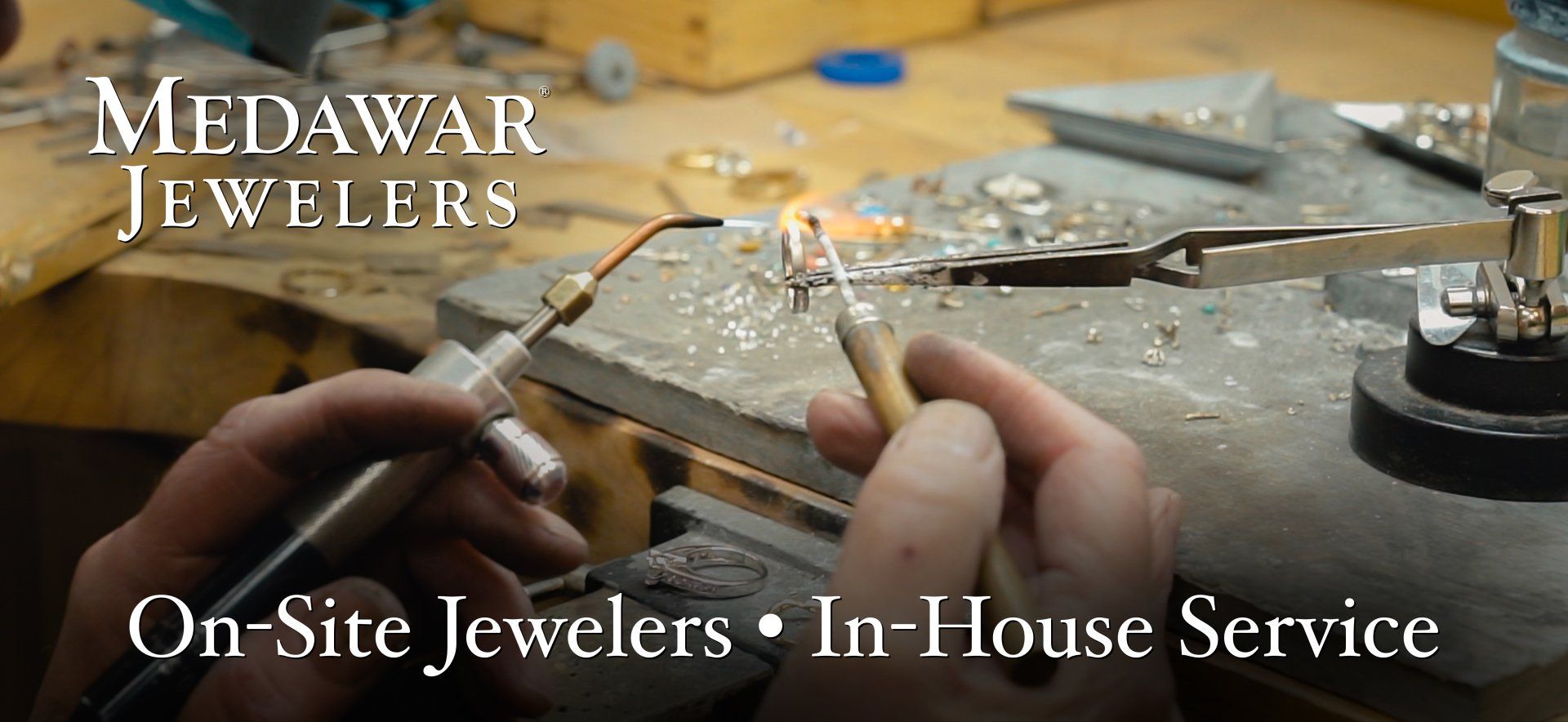 A person is working on a piece of jewelry with the words medawar jewelers on the bottom
