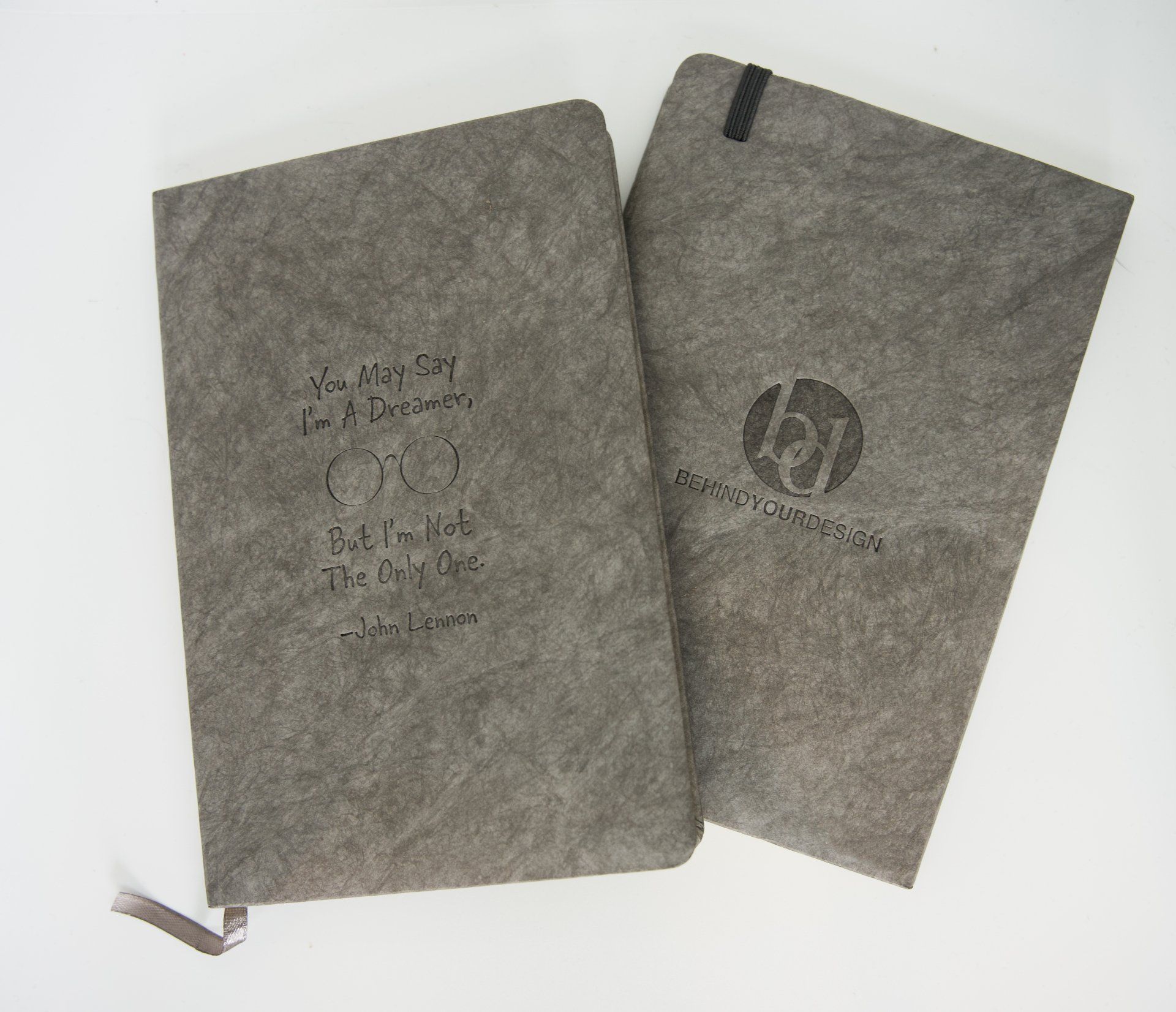 Two notebooks are sitting on a table and one says 