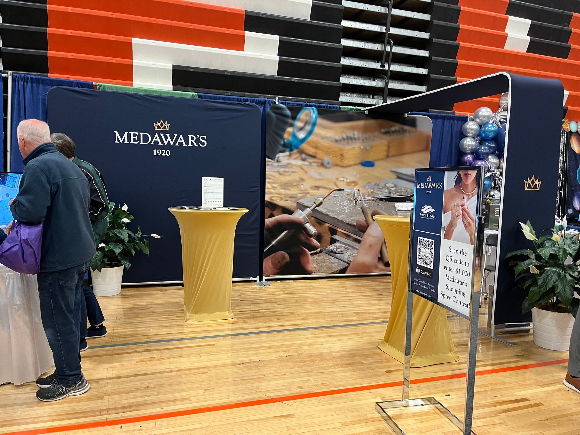 A group of people are standing in front of a booth.