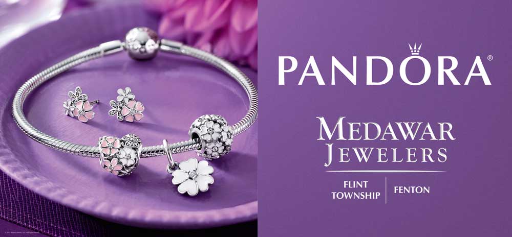 A pandora bracelet and earrings are on a purple plate