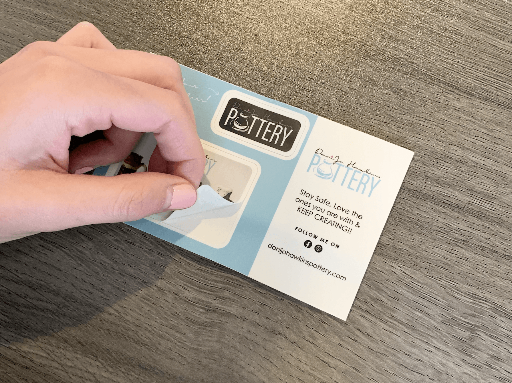 A person is holding a piece of paper that says pottery on it.