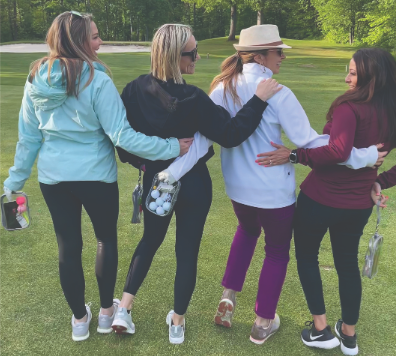a group of ladies playing golf holding clear pouches