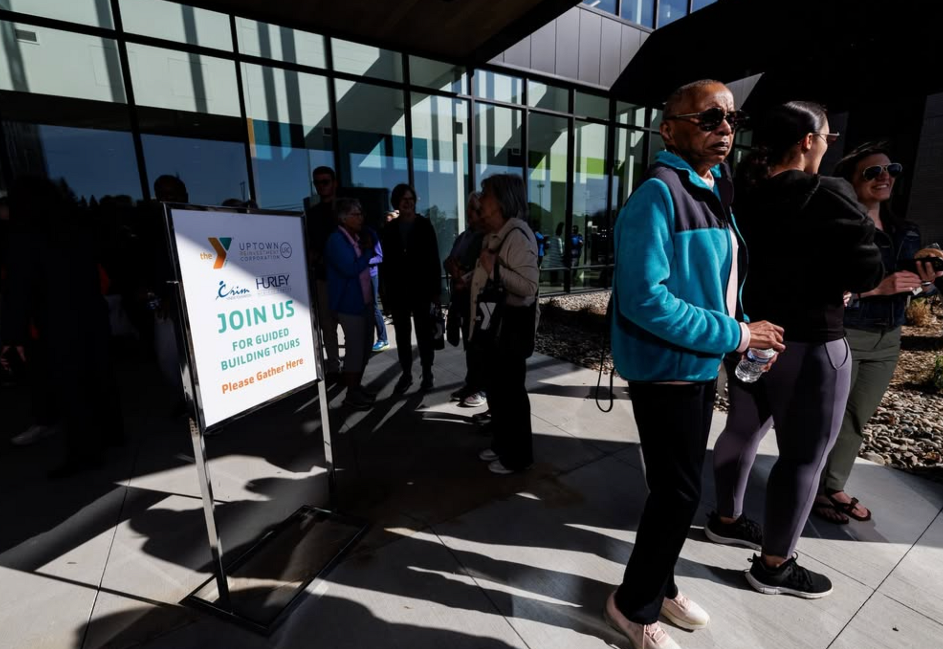 A group of people are standing in front of a sign that says join us