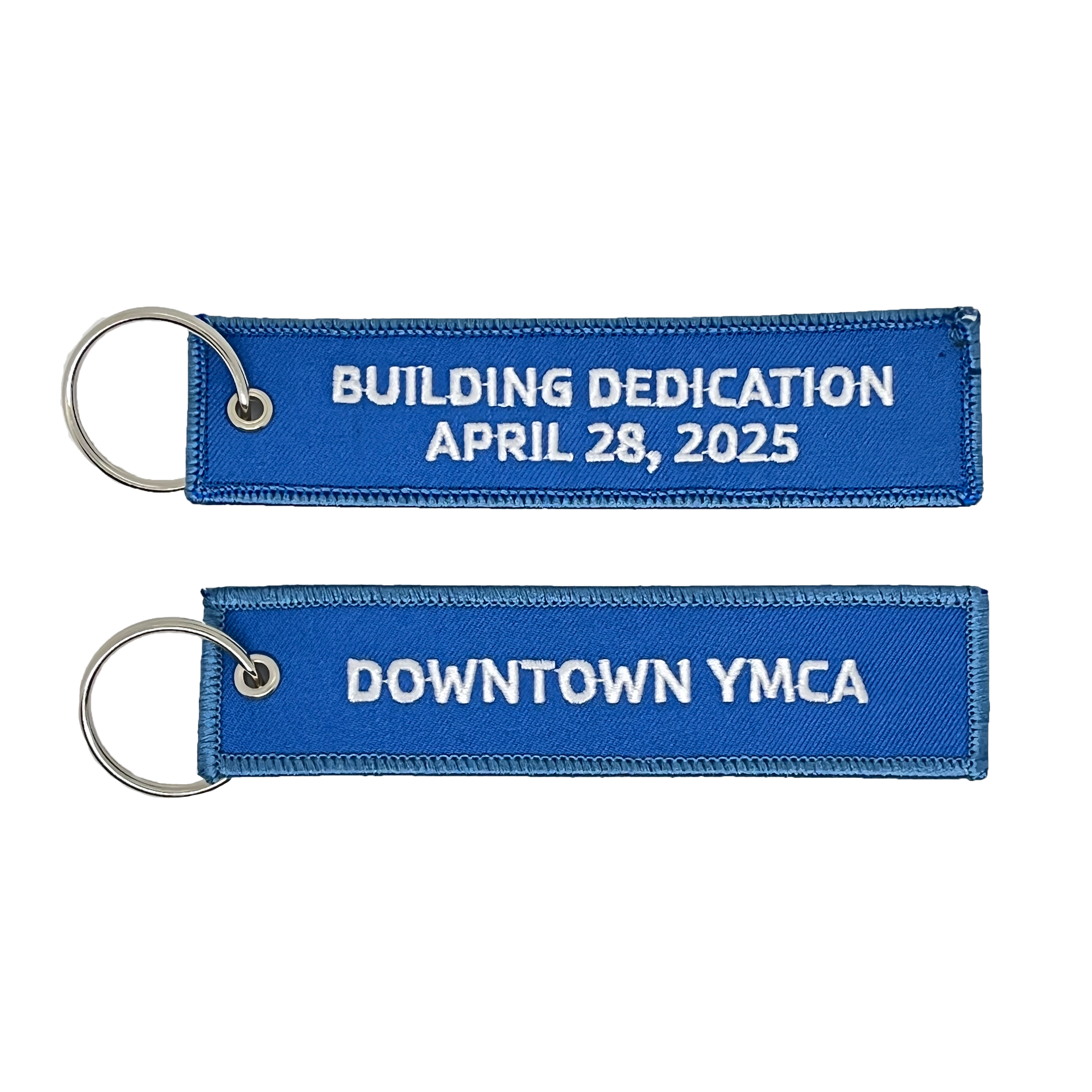A pair of blue keychains that say building dedication april 28 , 2025 downtown ymca