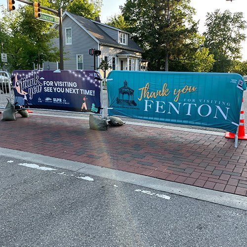 A thank you fenton sign is sitting on the side of the road.