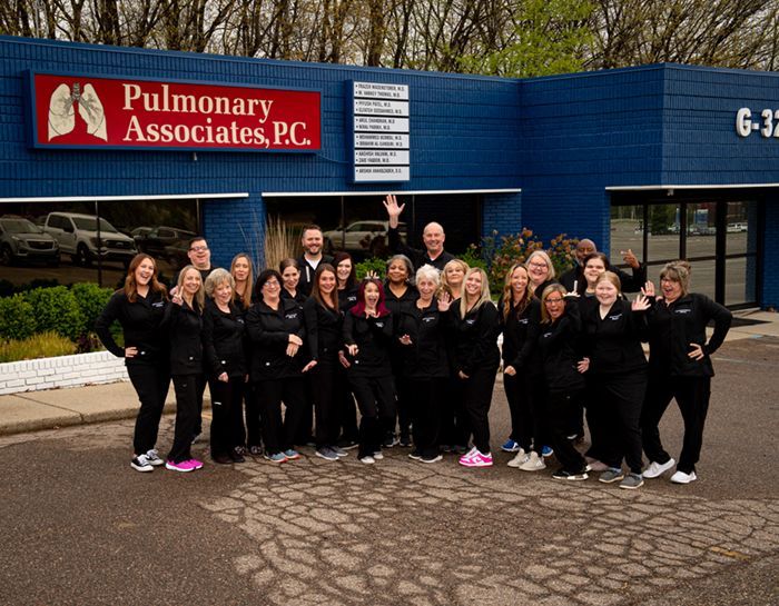 A group of people standing in front of a building that says pulmonary associates p.c.