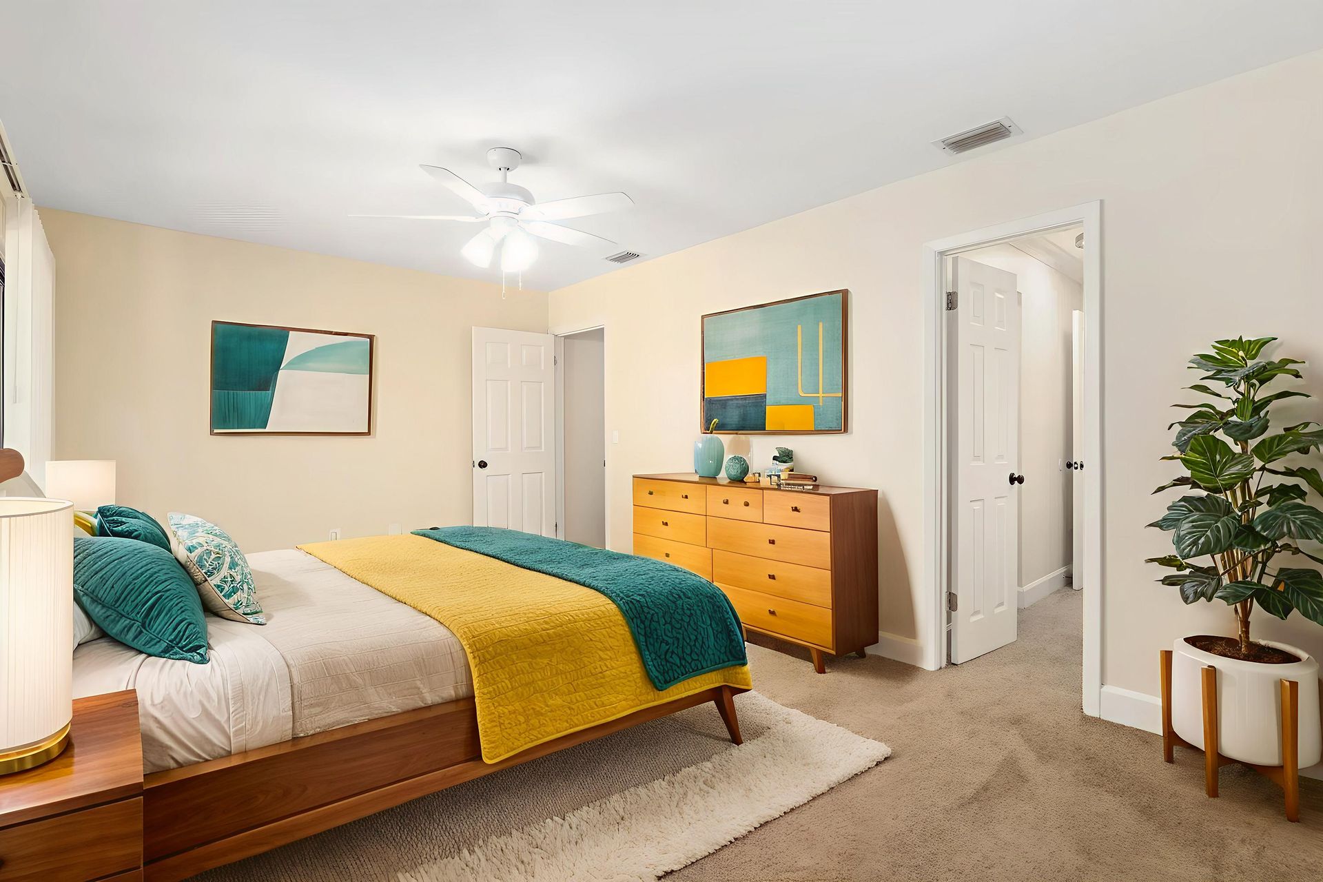 Bedroom with wooden furniture, teal and yellow accents, and a potted plant.