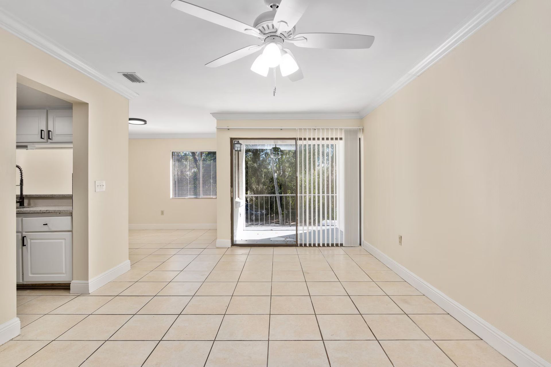 Empty room with tiled floor, sliding glass door, and white walls.
