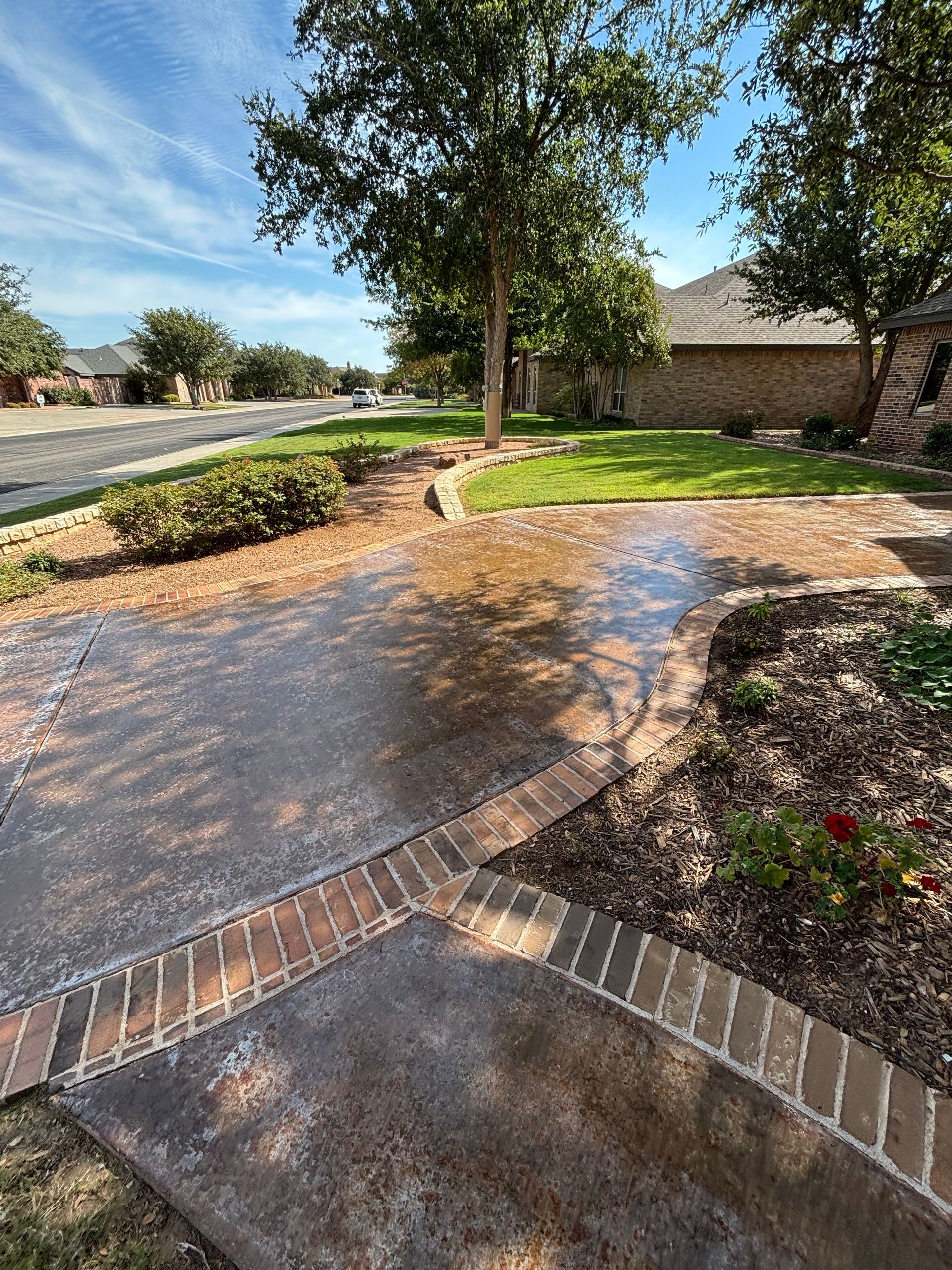 Brick building with concrete walkway, green lawn, and sunny sky.