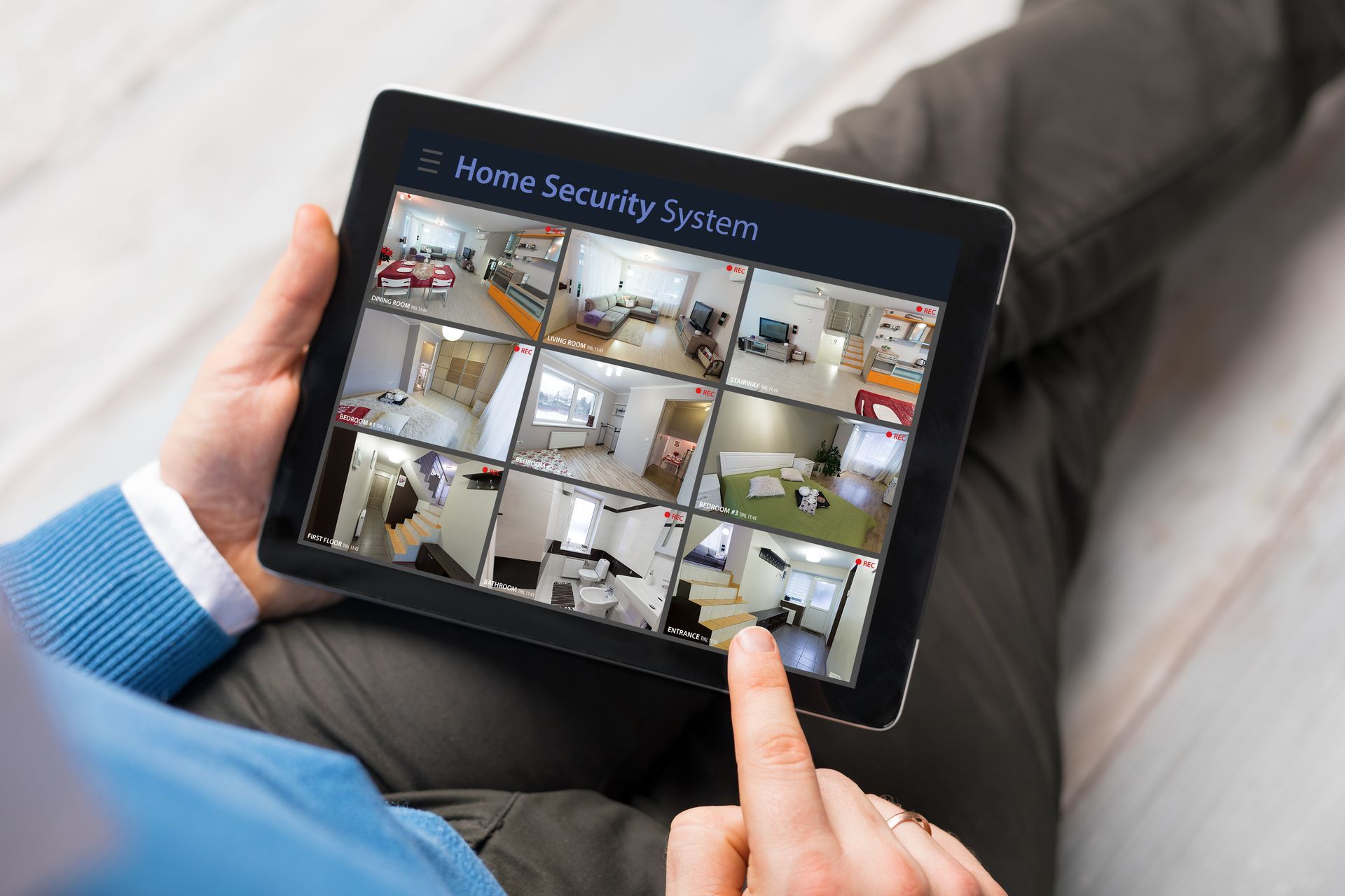 Tablet displaying home security system with multiple indoor camera views.