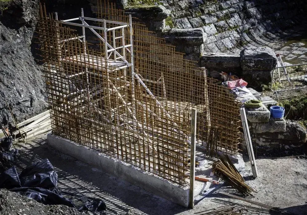 Construction site with rebar framework and wooden supports.