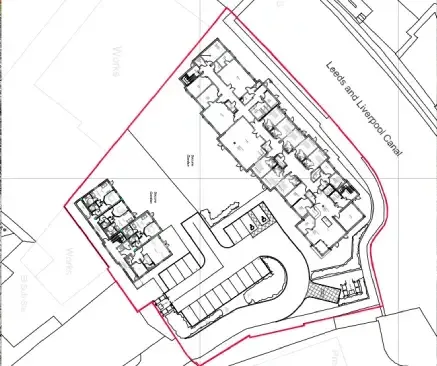Architectural site plan. Buildings, parking, and canal outlined in red, located near