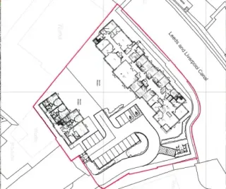 Architectural site plan. Buildings, parking, and canal outlined in red, located near 