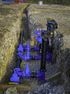 Blue water pipes and valves installed in an open trench, construction site.