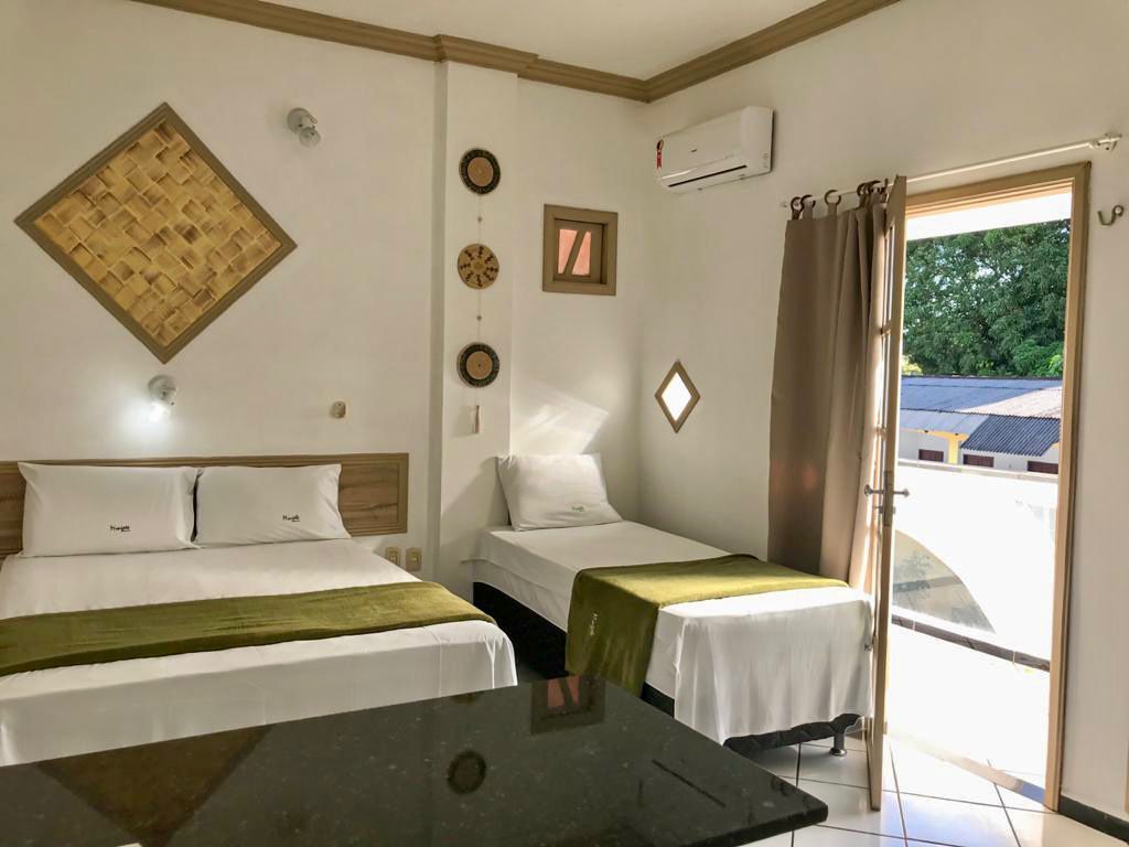 Um quarto de hotel com duas camas e uma mesa.