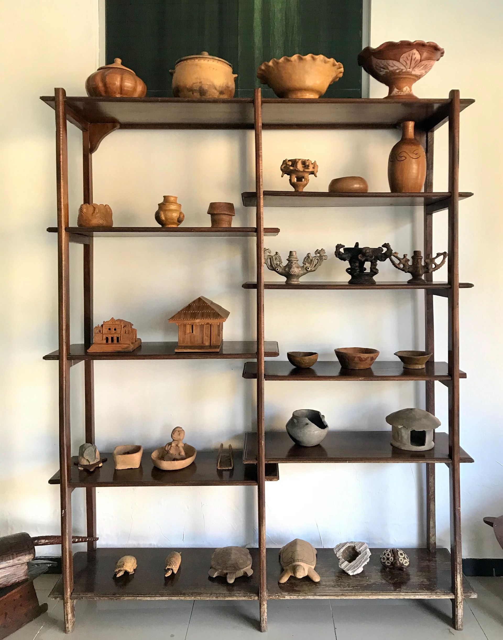 Uma prateleira de madeira com muita cerâmica