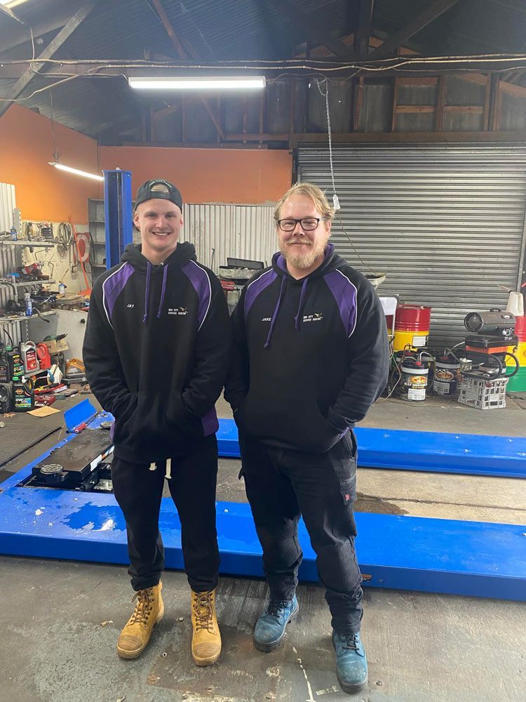 Two Men Are Standing Next To Each Other In A Garage — Licensed Mechanic in Albury, NSW
