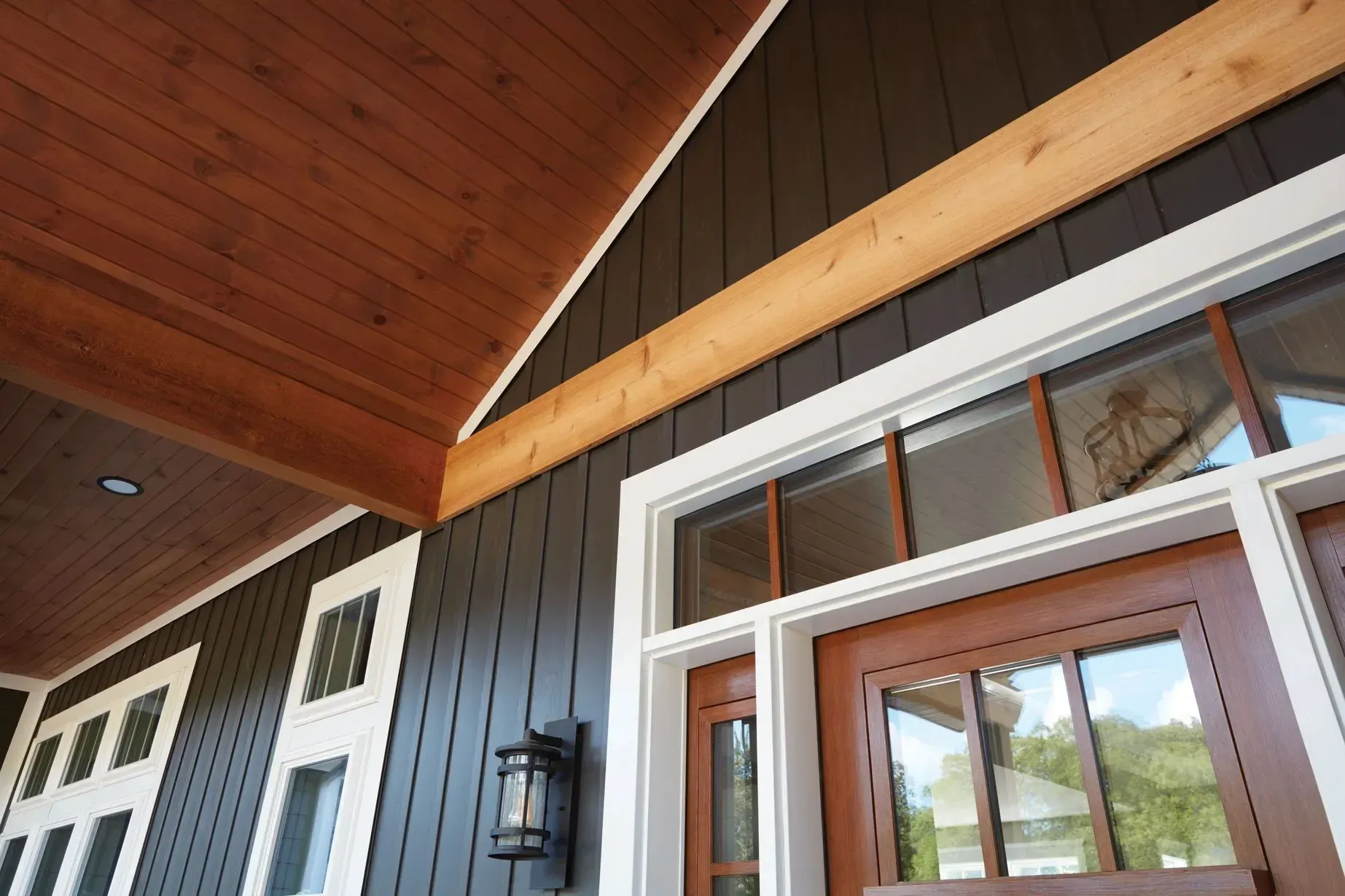 Dark brown house exterior with wooden beams, white trim, and a brown door.