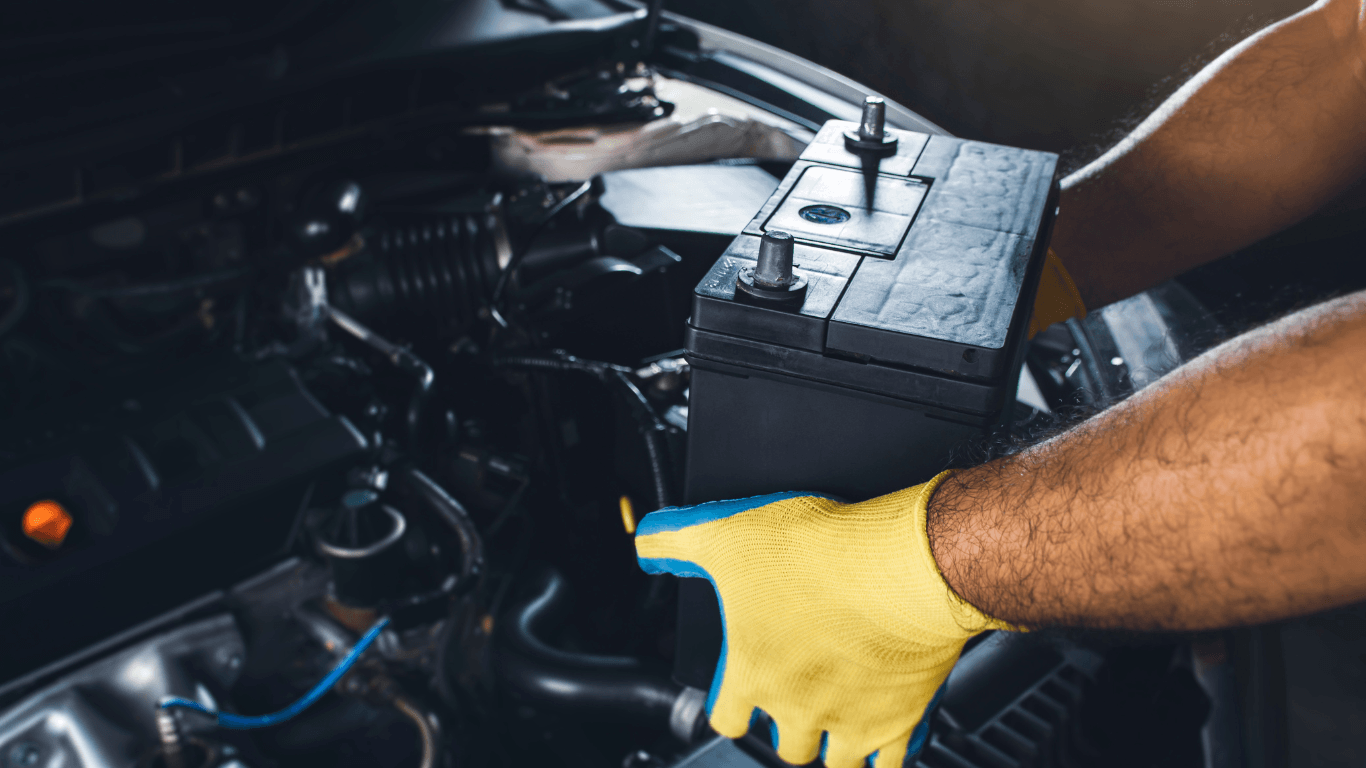 a mechanic performing a car battery replacement