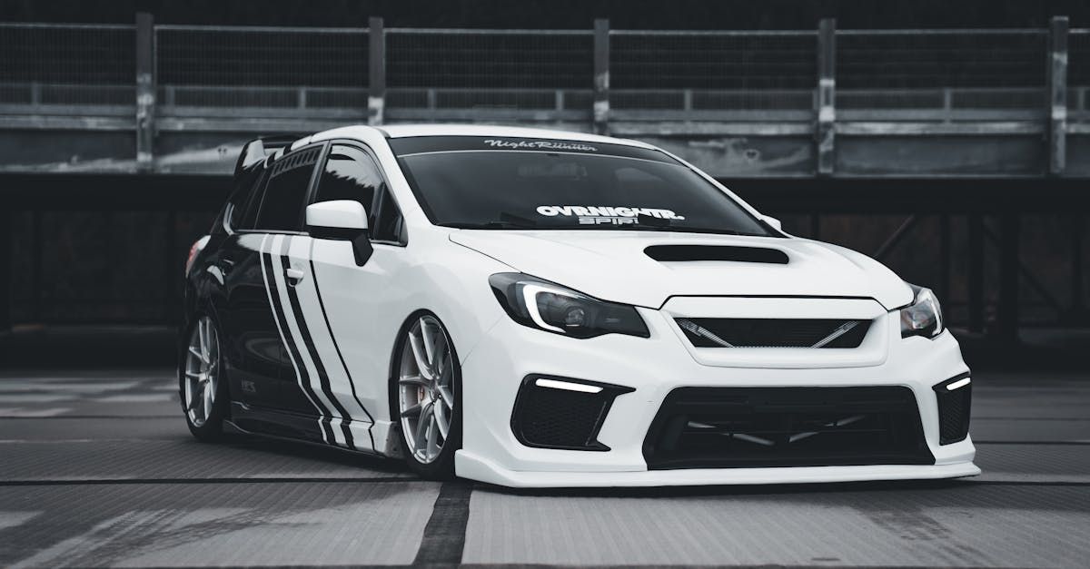 A black and white photo of a white car parked in a parking lot.  | Bock Automotive