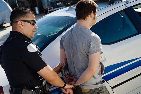 Officer Arresting Man In Gray — St. Minneapolis, MN — Absolute Bail Bonds