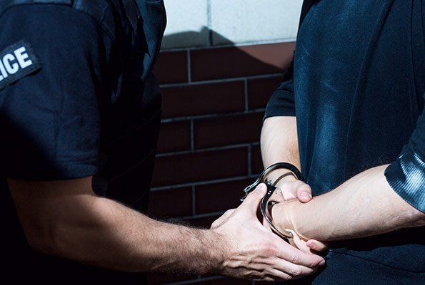 Police Officer Holding Man's Hands — St. Minneapolis, MN — Absolute Bail Bonds