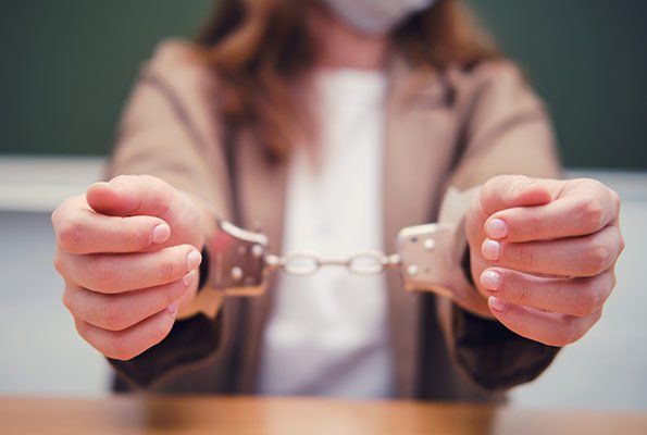 Close Up Of Woman Wearing Handcuffs — St. Minneapolis, MN — Absolute Bail Bonds