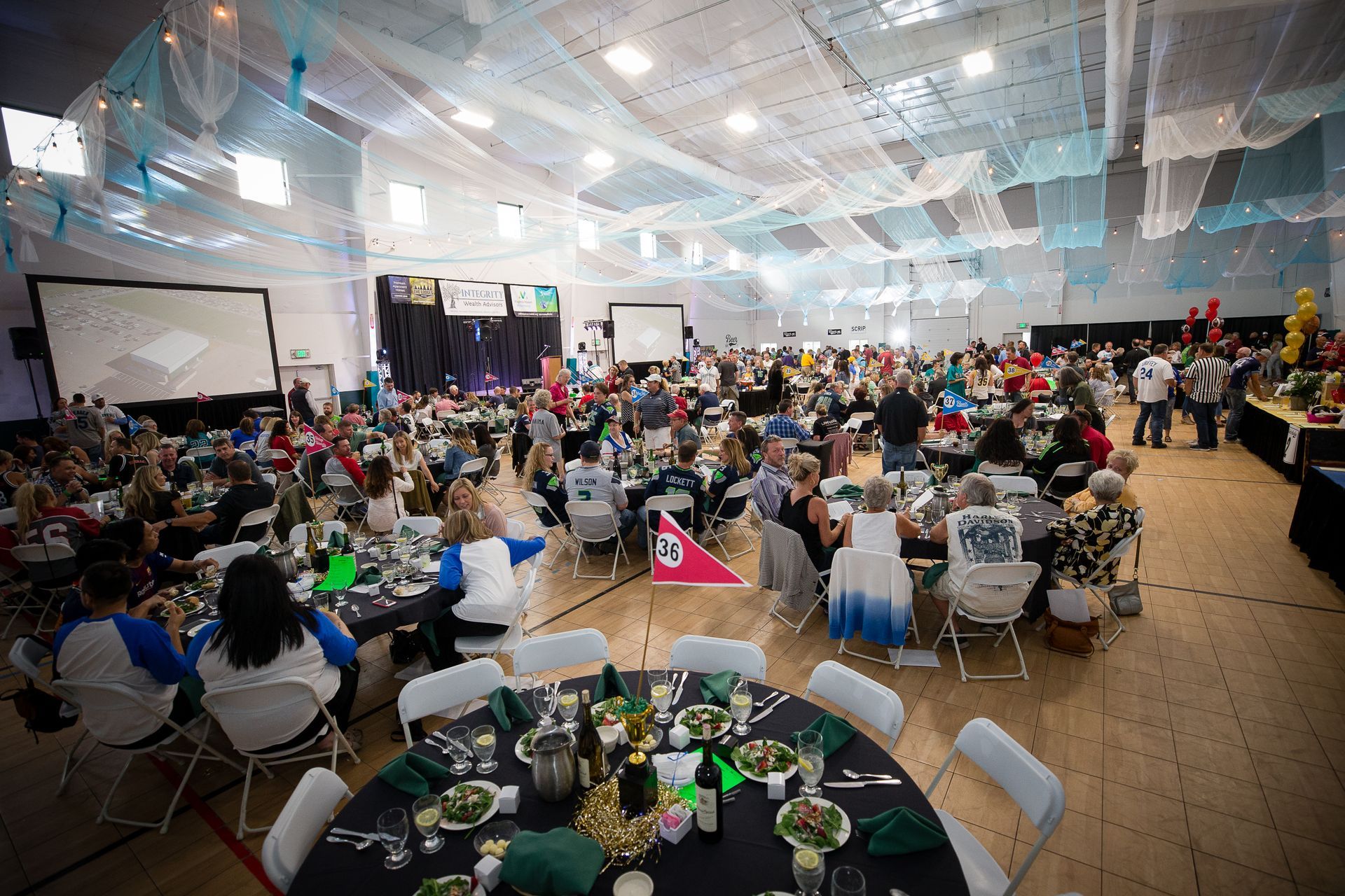 A large group of people are sitting at tables in a large room.
