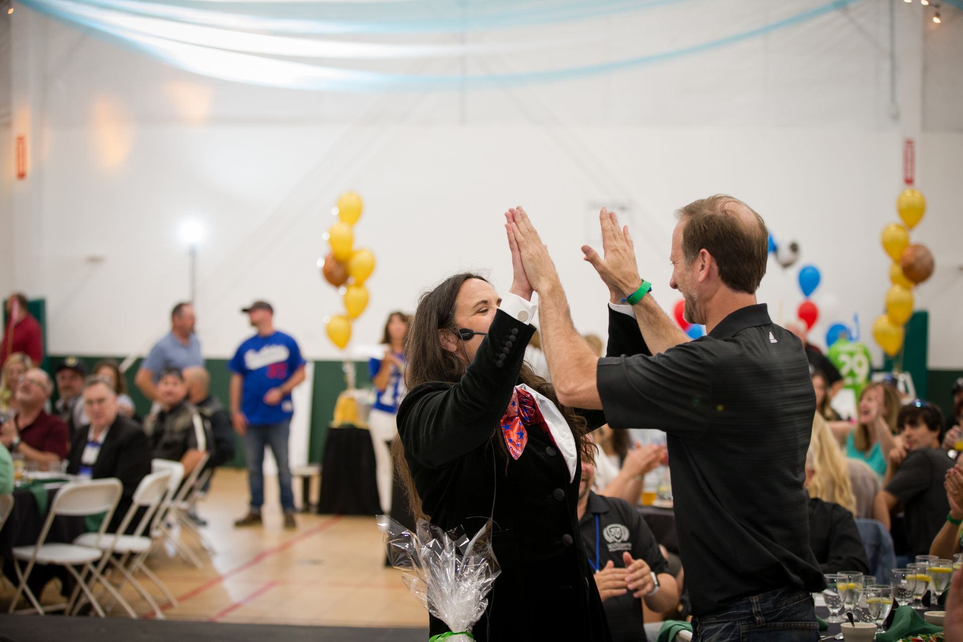 A man is giving a woman a high five at a party.