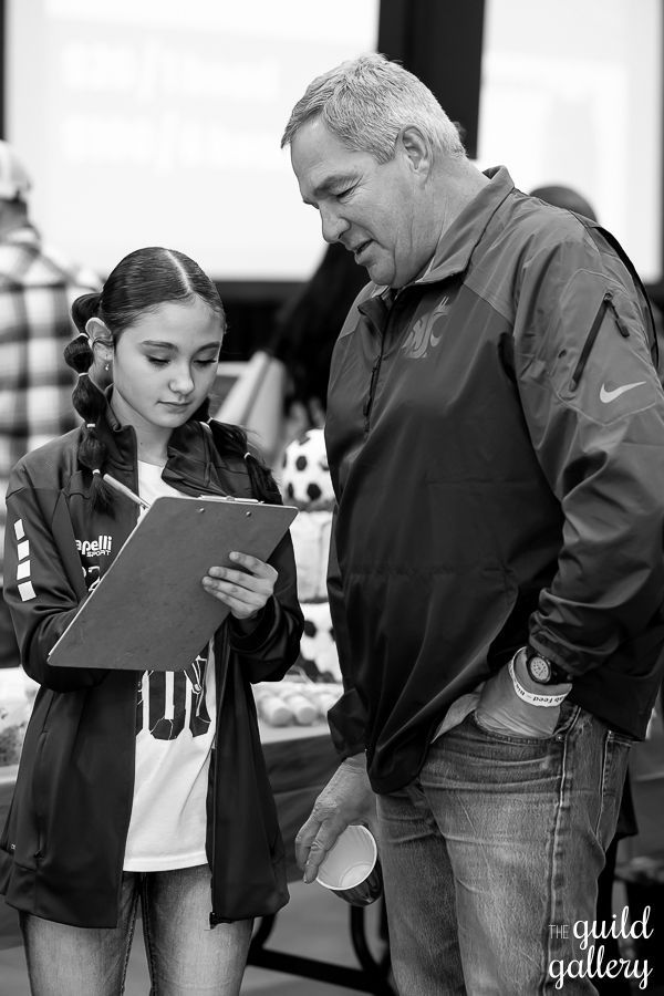 A man and a girl are looking at a piece of paper.