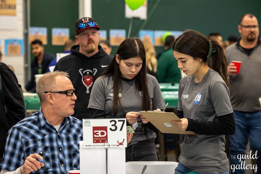 A group of people are standing around a table with a sign that says 37 on it.