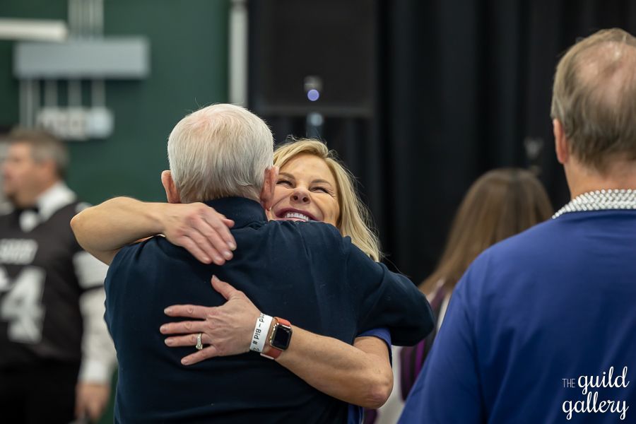 A woman is hugging a man in a room.