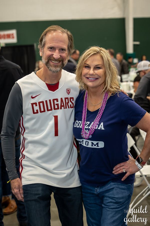 A man and a woman are posing for a picture . the man is wearing a cougars jersey.