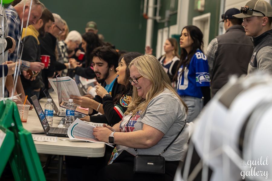 A group of people are sitting at a table with laptops.
