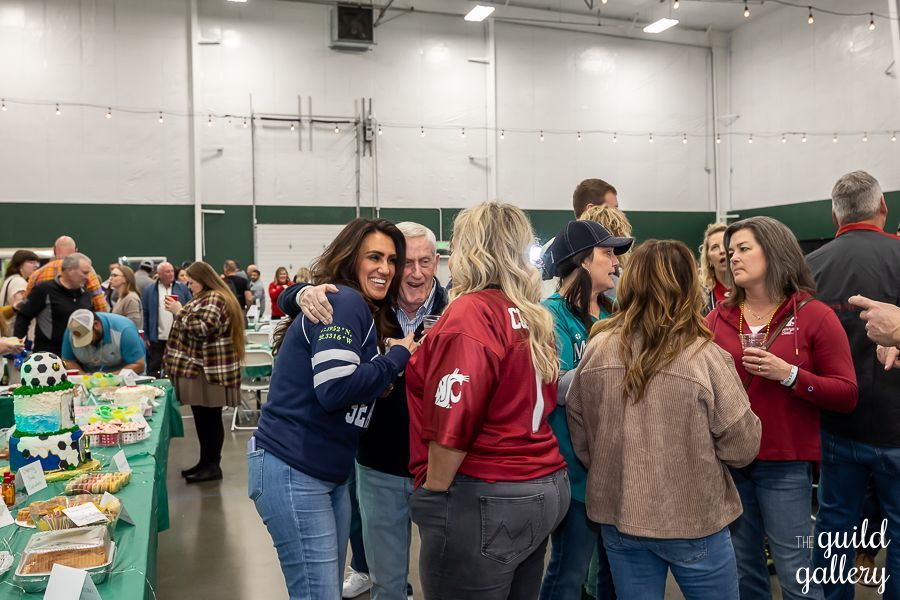A group of people are standing around a table in a room.