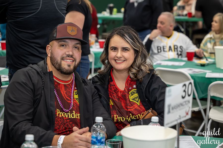 A man and a woman are sitting at a table at a party.